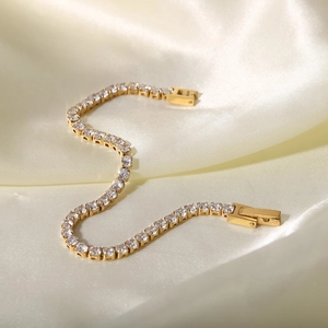 Bracelet rivière en or avec zircons blancs sur fond en soie de couleur champagne
