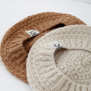 Berretto in maglia per bambini nei colori caramello e bianco crema per l'inverno