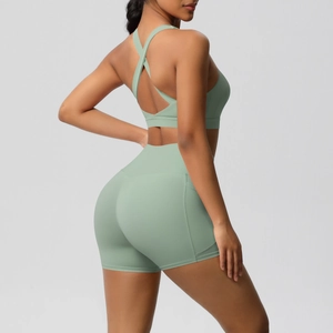 Detail of cross-back sports bra and high-waist shorts in mint green stretch fabric