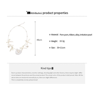 Detail of ribbon bow necklace with imitation pearls and heart pom-pom pendant
