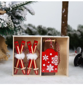 Detailed view of red wooden Christmas ski and sled ornaments in a snowy gift box