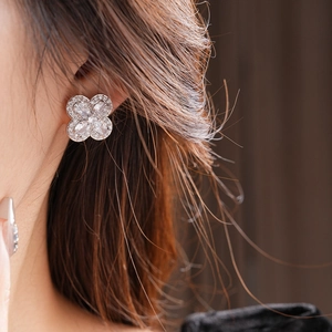 Détail d'une boucle d'oreille trèfle en argent avec cristaux de zircone sur l'oreille