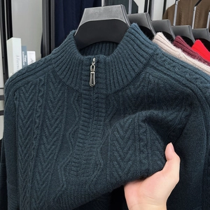 Close-up of thick cable knit texture and zipper detail on dark green winter sweater