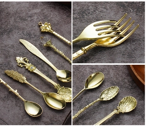 Detailed view of vintage gold coffee spoons with ornate crown and crystal handle designs