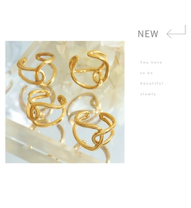 Detail of 18K gold-plated double-layer crossover ring on luxury acrylic display stand