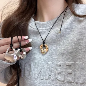 Irregular lava heart pendant necklace with black cord shown on model for minimalist style
