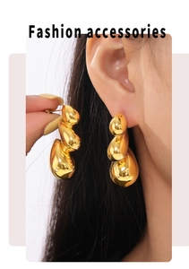 Detail of bohemian gold teardrop earrings showing the fluid triple-stacked liquid design