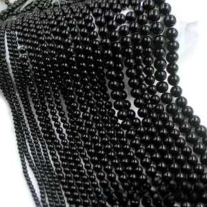 Close-up of polished black glass beads in various sizes for DIY jewelry making