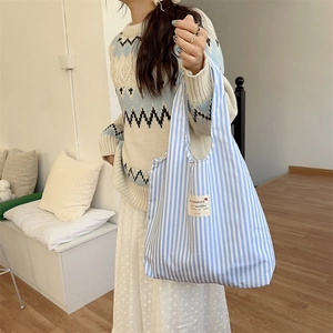 Detailansicht der blau-weiß gestreiften Canvas-Tasche mit dekorativem Text-Patch