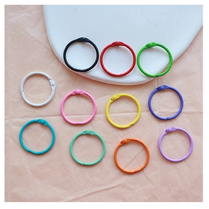 Close-up of colorful metal loose-leaf binder rings in 11 assorted lacquer finishes