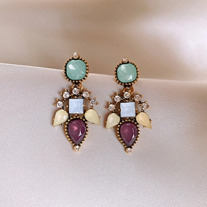 Vintage gold earrings with colorful floral resin crystals and diamond accents on silk