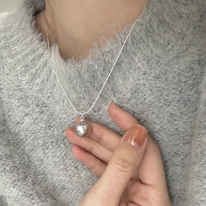 Elegant silver-tone snake chain necklace with a large grey pearl pendant worn by model