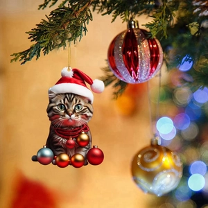 Close-up of acrylic chubby cat ornament with Christmas balls on a blurred festive tree