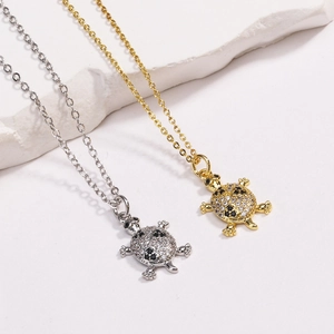 Detailed view of turtle pendants featuring black and white zircons in gold and silver finish