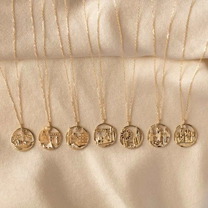 Detailed relief of world landmarks on gold coin pendants over elegant satin fabric