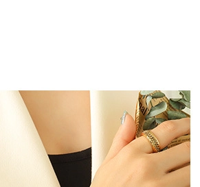 Detailed close-up of a wide gold Cuban chain engraved ring on a finger in retro style