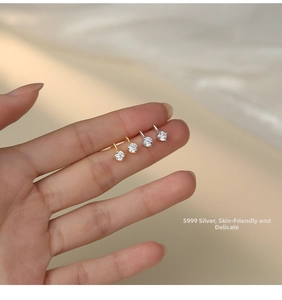 Macro shot of S999 sterling silver stud earrings in gold and silver with zircon