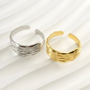 Detail of gold and silver adjustable steel rings with unique irregular textured surfaces