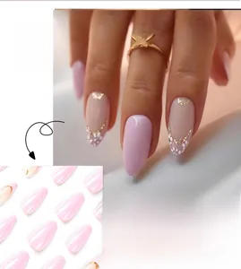Detail view of pink oval press-on nails with white floral patterns and gold accents