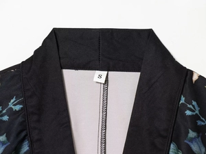 Detail of V-neckline on floral print blazer with blue blossoms and size S label