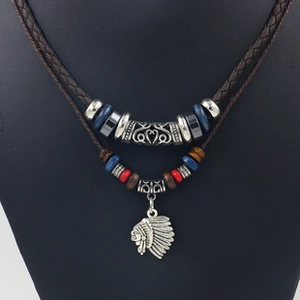 Close-up of double-layer braided leather necklace with Indian head pendant on a black bust