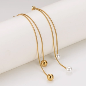 Golden snake chain drop earrings with white pearl and gold bead tassels on white display