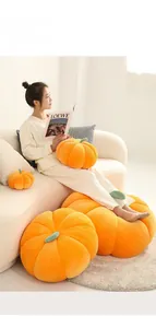 Detail of soft orange velvet pumpkin pillow with green stem in a cozy home setting