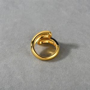 Dettaglio anello in ottone placcato oro 18K con smalto nero su sfondo di cemento grigio