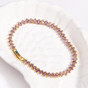 Macro detail of gold-plated tennis bracelet with marquee-cut purple zircon stones