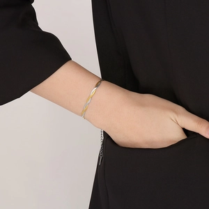 Close-up of two-tone braided snake chain bracelet with adjustable link on model