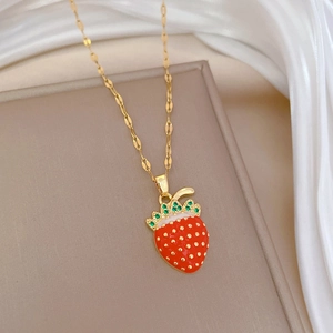 Detailed view of luxury strawberry pendant with red enamel and sparkling green crystals