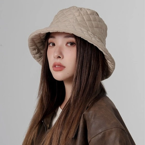 Détail du chapeau bob matelassé beige montrant les coutures et la texture d'hiver