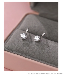 Macro shot of silver stud earrings with round cubic zirconia in four-prong setting