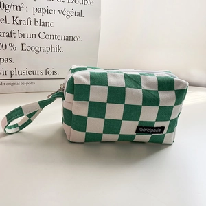 Detalle del estuche de lona de cuadros verdes con etiqueta tejida de merciparis