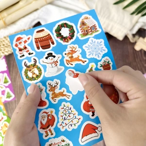 Close-up of peeling waterproof Christmas stickers with Santa and reindeer motifs