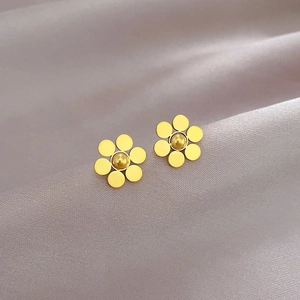 Minimalist golden six-petal flower stud earrings in titanium steel on pink silk background