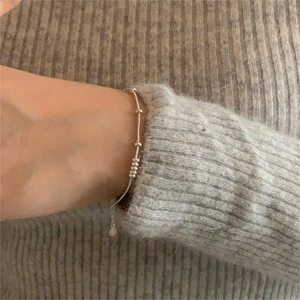 Detail of a minimalist 925 sterling silver snake chain bracelet with small beads