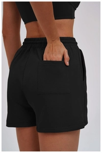 Detail view of high-waist sports shorts featuring a back pocket and soft knit texture