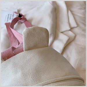 Macro detail of creamy canvas backpack showing cute ear design and pink webbing straps