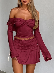 Detail of burgundy off-shoulder long sleeve top and ruffled mini skirt set with pleated waist