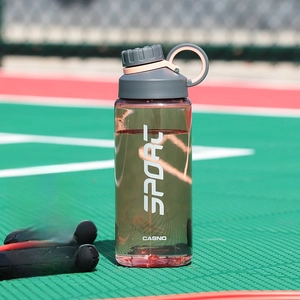 Close-up of 800ml burgundy sports water bottle with tea infuser on an outdoor court