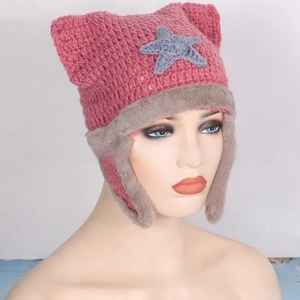 Detail of pink knitted star cat ear hat featuring gray faux fur lining and earflaps