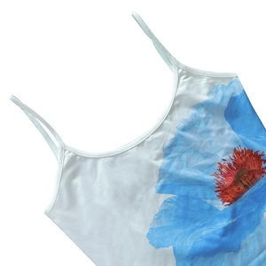 Detailed view of the white floral camisole featuring blue flowers and delicate thin straps