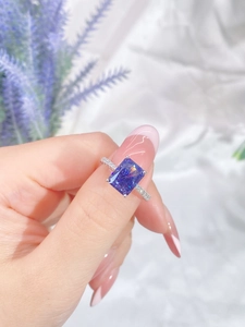 Macro view of blue rectangular cushion cut zircon ring with micro-pave diamonds