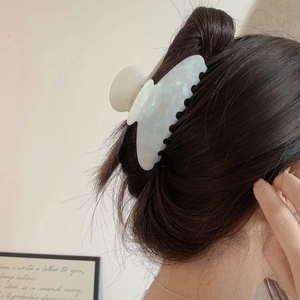 Close-up of marble acetate hair claw clip with golden Barrette La France lettering