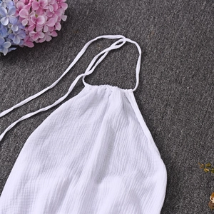 Detailed close-up of white halter neck top featuring textured crinkle fabric and strap details