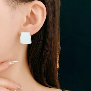 Vue rapprochée d'une boucle d'oreille géométrique en résine avec cadre argenté