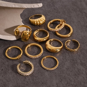 Polished gold-plated 10-piece ring set with cubic zirconia on gray textured stone surface