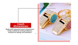 Detail of whistle-shaped metal keychains featuring sparkling rhinestones in blue and pink