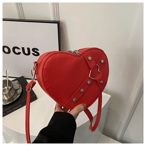 Détails du sac bandoulière rouge en forme de cœur avec clous et boucle métallique